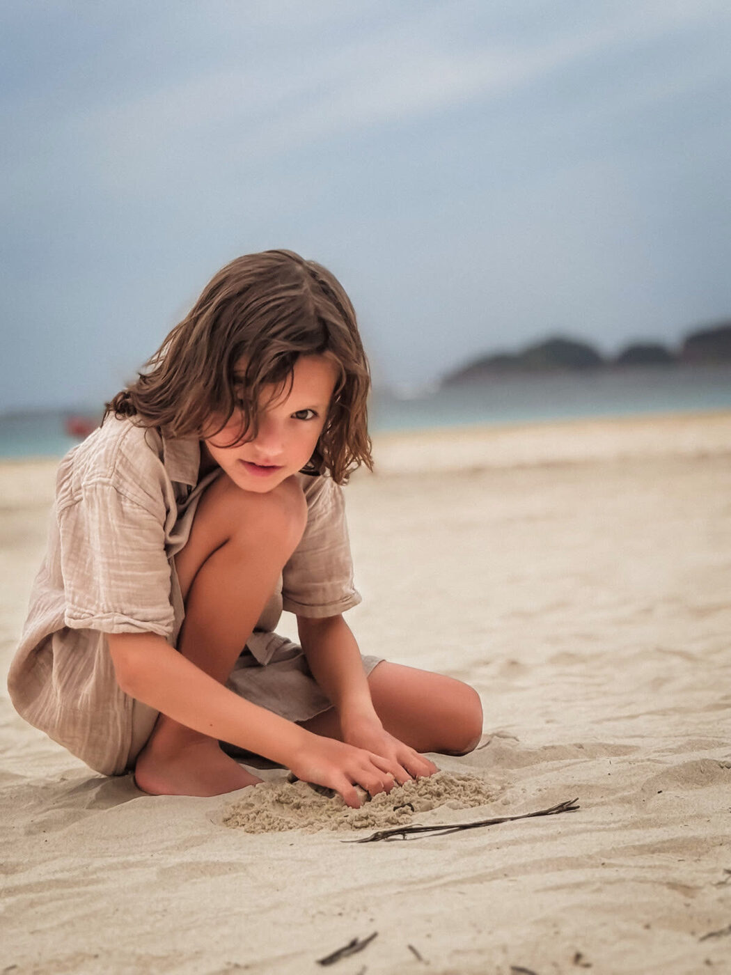 UGC photo for a linen brand, kid playing on the beach